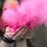 Blowing a burst of bright pink paint