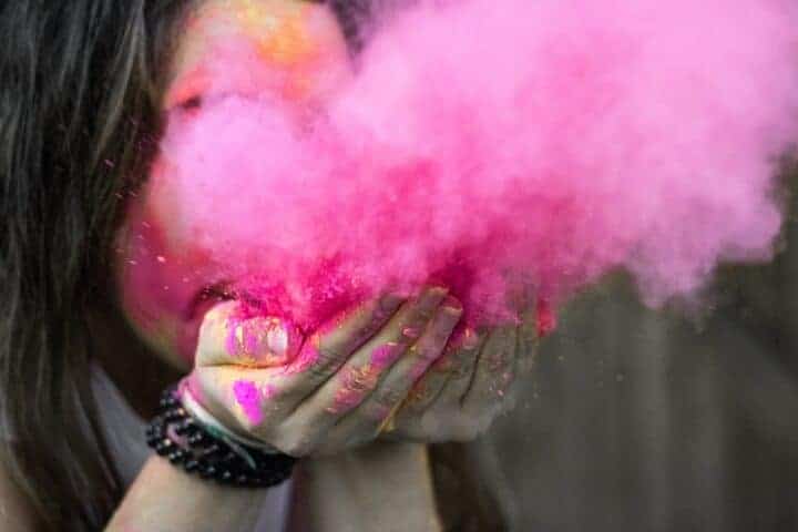 Blowing a burst of bright pink paint