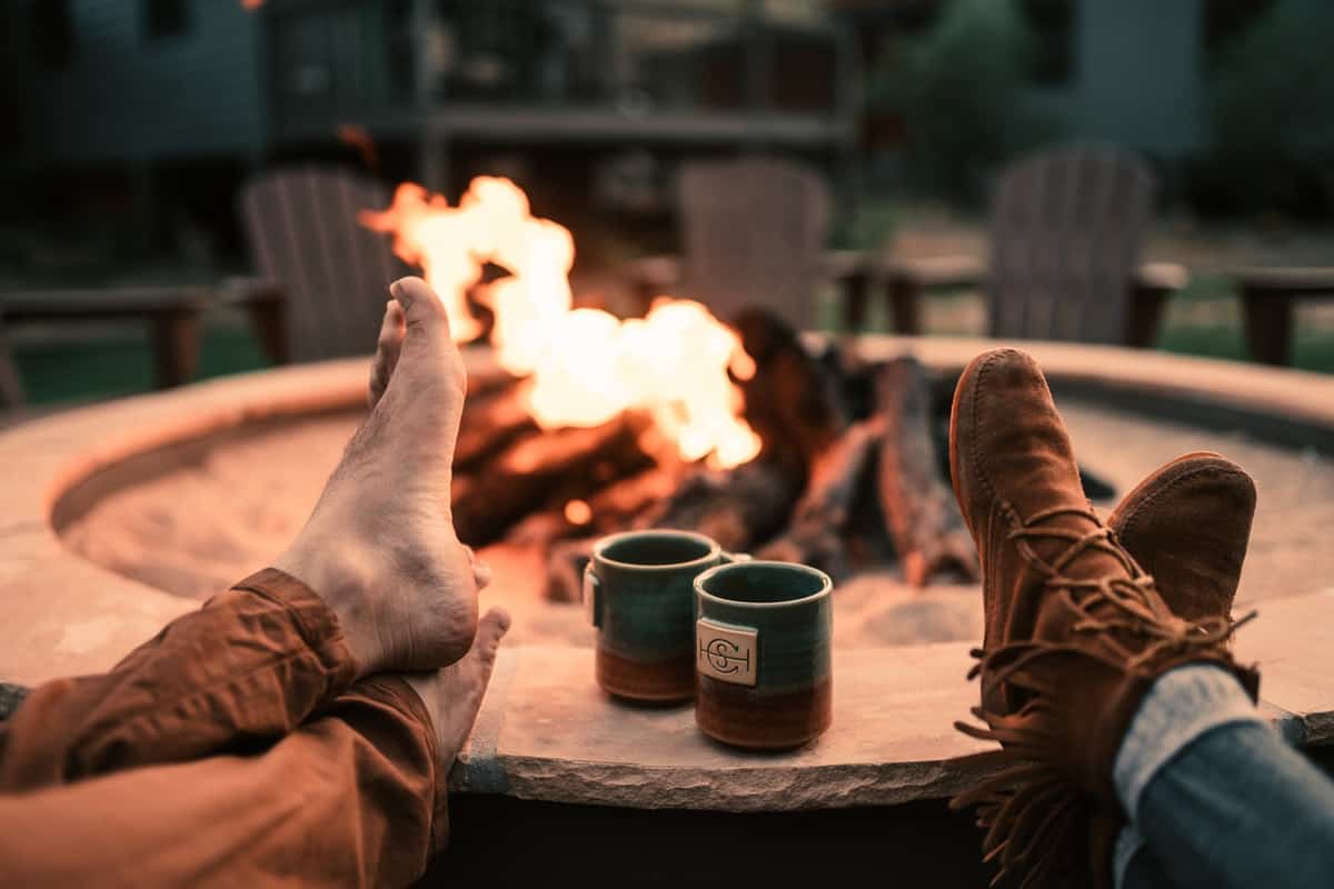 Happy couple with there feet up sitting with the fire